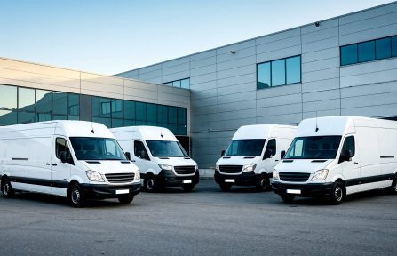 white-delivery-vans-parked-outside-warehouse